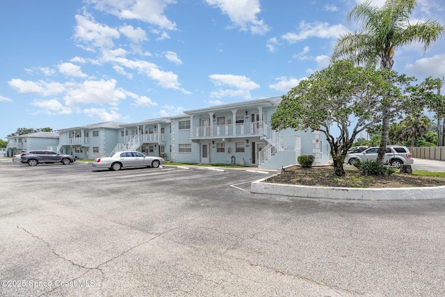 1005 Knox Mcrae Dr Unit B-210, Titusville, FL 32780 - view of property featuring stairs, uncovered parking, and a residential view