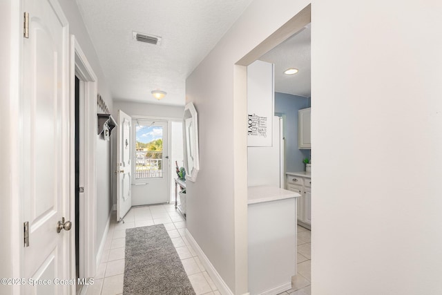 1005 Knox Mcrae Dr Unit B-210, Titusville, FL 32780 - corridor with light tile patterned floors and a textured ceiling