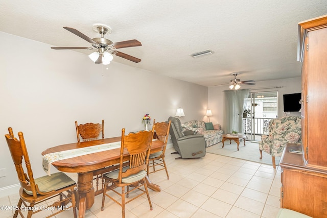 1005 Knox Mcrae Dr Unit B-210, Titusville, FL 32780 - dining room featuring a ceiling fan, light tile patterned flooring, and a textured ceiling