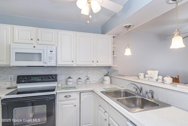 1005 Knox Mcrae Dr Unit B-210, Titusville, FL 32780 - kitchen with white microwave, electric range oven, white cabinetry, ceiling fan, and backsplash