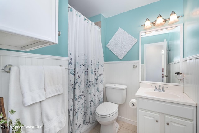 1005 Knox Mcrae Dr Unit B-210, Titusville, FL 32780 - bathroom with wainscoting, vanity, tile patterned floors, and a shower with curtain