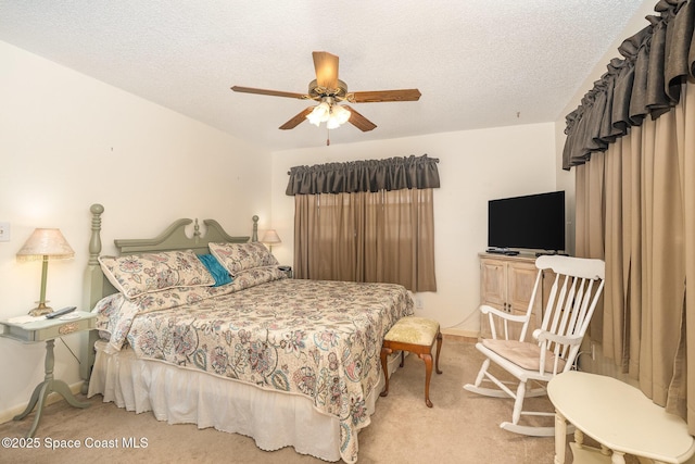1005 Knox Mcrae Dr Unit B-210, Titusville, FL 32780 - bedroom with carpet floors, a textured ceiling, and a ceiling fan