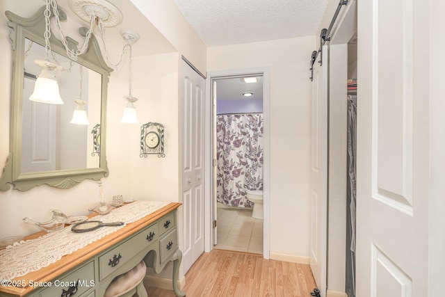 1005 Knox Mcrae Dr Unit B-210, Titusville, FL 32780 - full bath featuring vanity, wood finished floors, a textured ceiling, curtained shower, and a closet