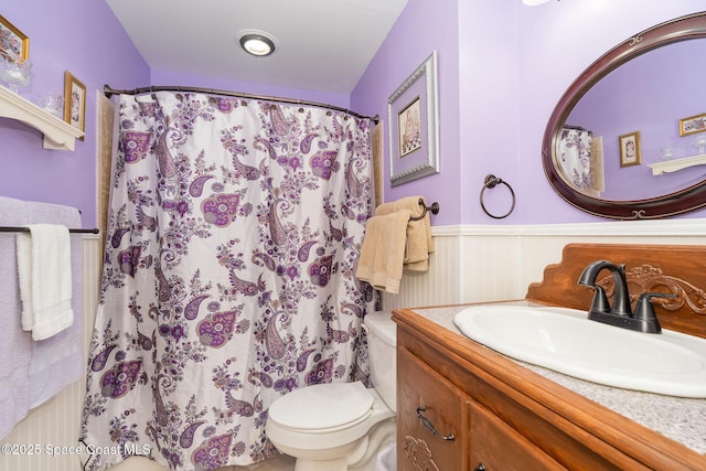1005 Knox Mcrae Dr Unit B-210, Titusville, FL 32780 - bathroom with wainscoting, vanity, and a shower with shower curtain