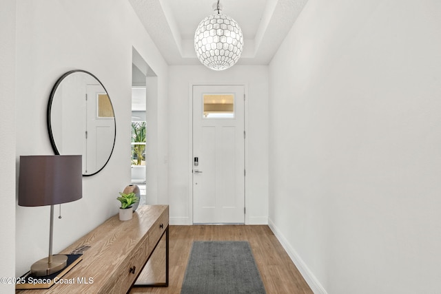 9374 Corvo Ct, Melbourne, FL 32940 - entryway with a raised ceiling, light wood-style flooring, and a chandelier