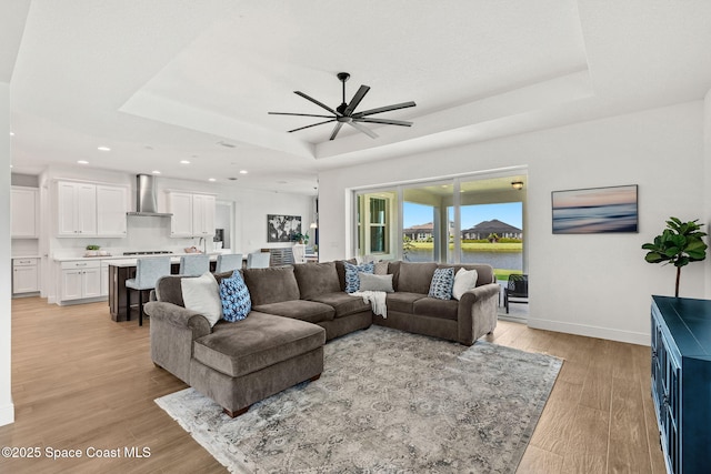 9374 Corvo Ct, Melbourne, FL 32940 - living area with a raised ceiling, ceiling fan, light wood-type flooring, recessed lighting, and a water view
