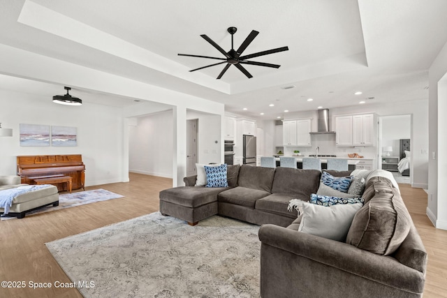 9374 Corvo Ct, Melbourne, FL 32940 - living room with a raised ceiling, ceiling fan, light wood finished floors, and recessed lighting