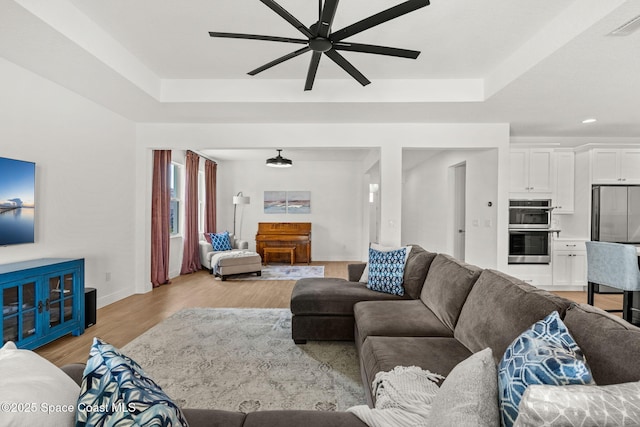 9374 Corvo Ct, Melbourne, FL 32940 - living room featuring a ceiling fan, a tray ceiling, light wood finished floors, and recessed lighting