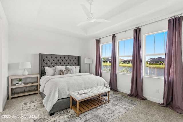 9374 Corvo Ct, Melbourne, FL 32940 - carpeted bedroom with a water view, a tray ceiling, and a ceiling fan