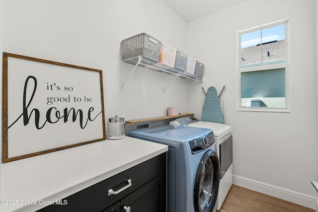 9374 Corvo Ct, Melbourne, FL 32940 - laundry room with washing machine and dryer, cabinet space, and light wood-style flooring