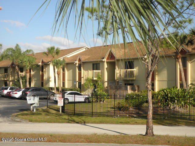 2101 Forest Knoll Dr NE Unit 01-101, Palm Bay, FL 32905 - view of building exterior with uncovered parking