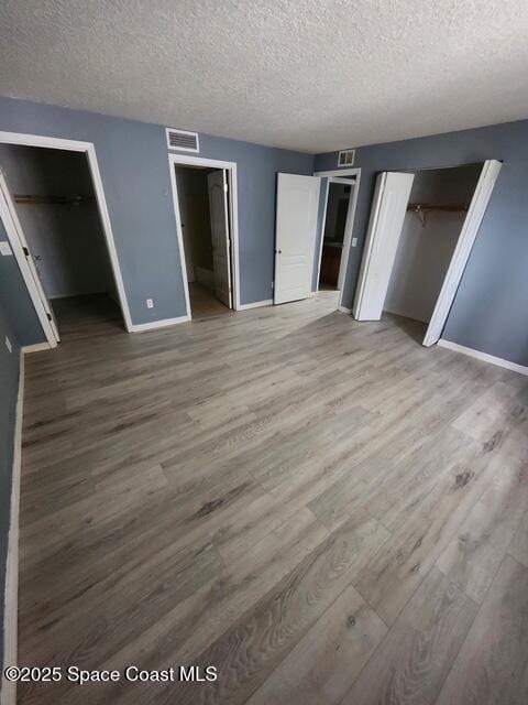 2101 Forest Knoll Dr NE Unit 01-101, Palm Bay, FL 32905 - unfurnished bedroom featuring wood finished floors and a textured ceiling