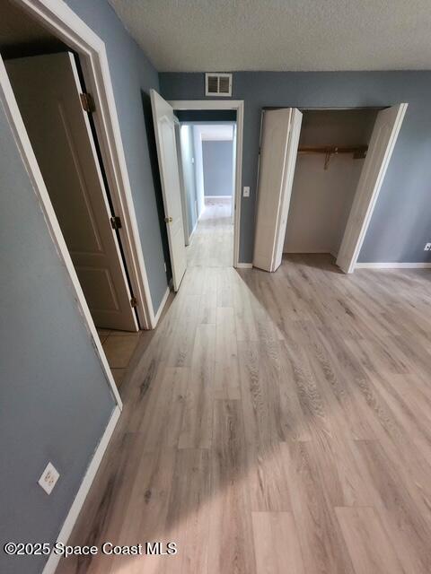2101 Forest Knoll Dr NE Unit 01-101, Palm Bay, FL 32905 - hall with light wood-style flooring and a textured ceiling