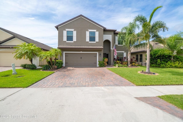 739 Fiddleleaf Cir, Melbourne, FL 32904 - traditional home featuring decorative driveway, stucco siding, a front lawn, and a garage