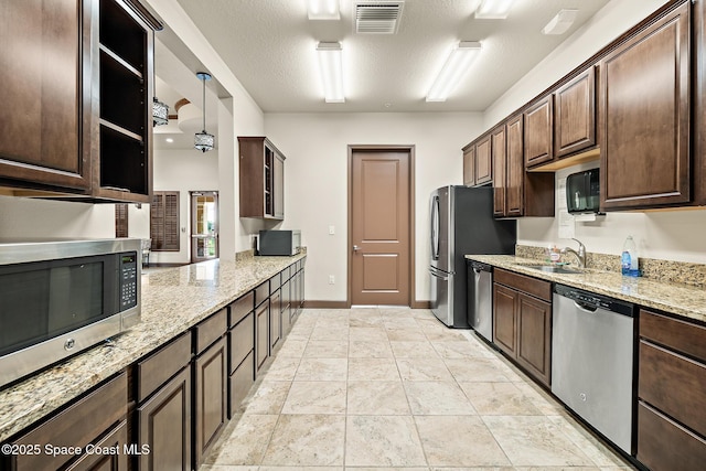 739 Fiddleleaf Cir, Melbourne, FL 32904 - kitchen with appliances with stainless steel finishes, dark brown cabinetry, light stone countertops, and a textured ceiling