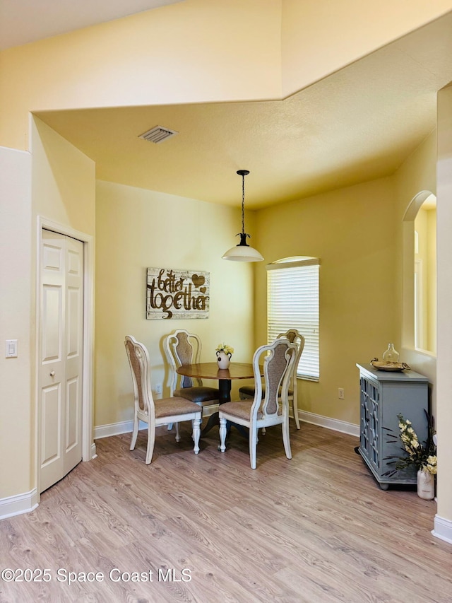 524 Mcguire Blvd, Indian Harbour Beach, FL 32937 - dining area with arched walkways and light wood-style flooring