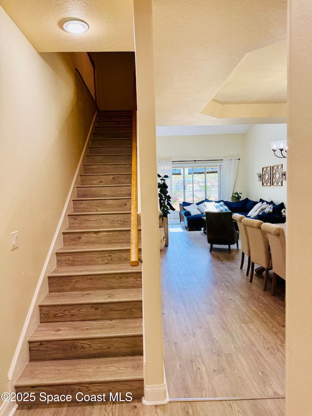 524 Mcguire Blvd, Indian Harbour Beach, FL 32937 - staircase featuring wood finished floors and a textured ceiling