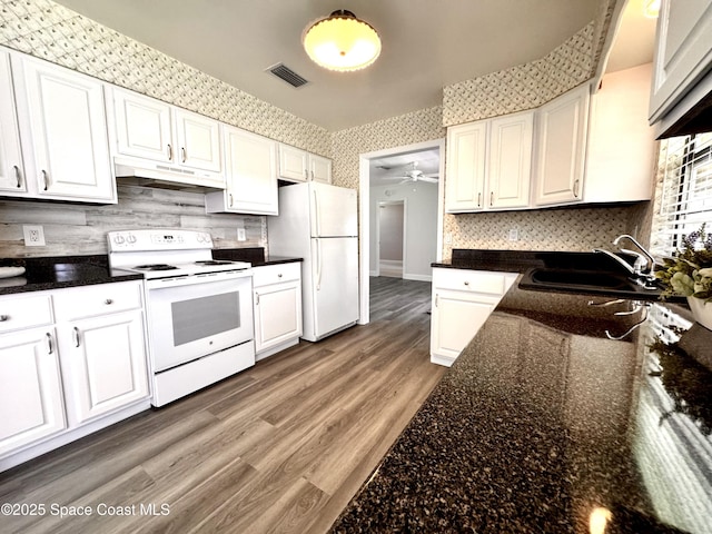 658 Ervin St, Sebastian, FL 32958 - kitchen featuring white appliances, under cabinet range hood, wallpapered walls, and white cabinets