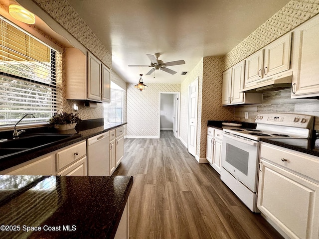 658 Ervin St, Sebastian, FL 32958 - kitchen featuring white appliances, under cabinet range hood, wallpapered walls, dark wood-type flooring, and ceiling fan