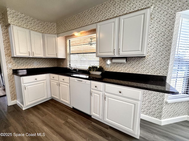 658 Ervin St, Sebastian, FL 32958 - kitchen featuring white dishwasher, wallpapered walls, dark wood-style floors, plenty of natural light, and white cabinets
