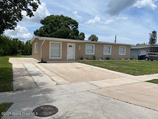 3037 Rowe St NE, Palm Bay, FL 32905 - ranch-style house featuring stucco siding, concrete driveway, and a front yard