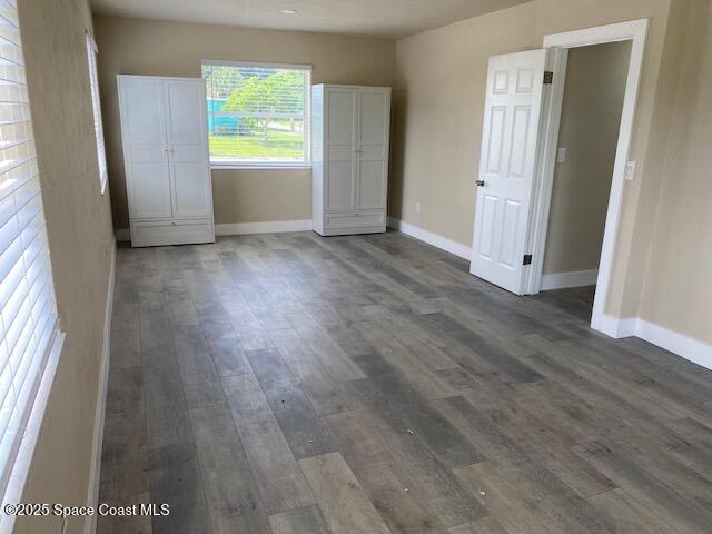 3037 Rowe St NE, Palm Bay, FL 32905 - unfurnished bedroom with baseboards and dark wood-type flooring