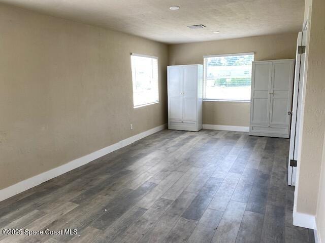 3037 Rowe St NE, Palm Bay, FL 32905 - unfurnished bedroom featuring baseboards and dark wood finished floors