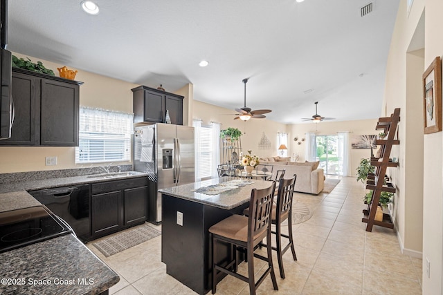 103 Amherst Ln, Sebastian, FL 32958 - kitchen featuring stainless steel fridge, a kitchen island, light tile patterned floors, a breakfast bar, and dishwasher