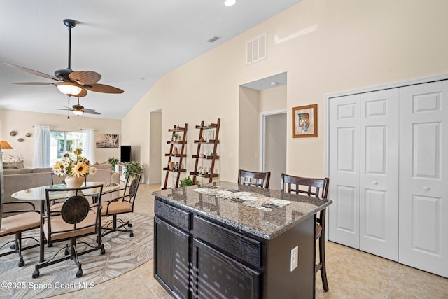 103 Amherst Ln, Sebastian, FL 32958 - kitchen featuring a breakfast bar area, light tile patterned flooring, ceiling fan, a center island, and stone countertops