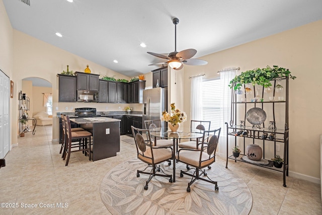 103 Amherst Ln, Sebastian, FL 32958 - dining area featuring arched walkways, healthy amount of natural light, ceiling fan, vaulted ceiling, and light tile patterned flooring