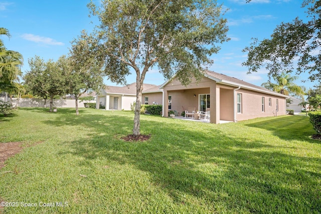 103 Amherst Ln, Sebastian, FL 32958 - rear view of house featuring stucco siding, a lawn, and a patio area