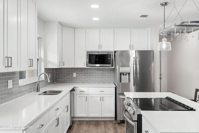 1119 Manatee Dr, Rockledge, FL 32955 - kitchen featuring stainless steel appliances, light countertops, light wood-style flooring, white cabinets, and recessed lighting