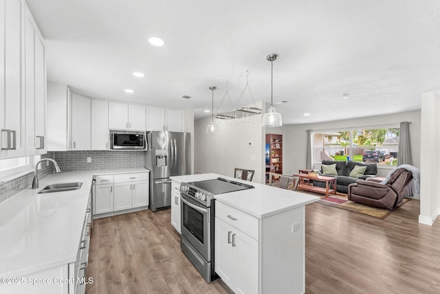 1119 Manatee Dr, Rockledge, FL 32955 - kitchen featuring stainless steel appliances, a center island, light countertops, white cabinetry, and recessed lighting
