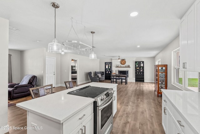 1119 Manatee Dr, Rockledge, FL 32955 - kitchen with open floor plan, stainless steel electric range oven, light countertops, pendant lighting, and white cabinets