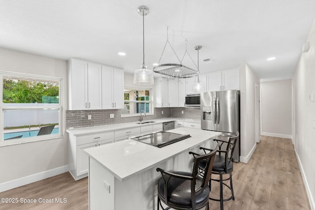 1119 Manatee Dr, Rockledge, FL 32955 - kitchen featuring stainless steel appliances, backsplash, light countertops, healthy amount of natural light, and recessed lighting