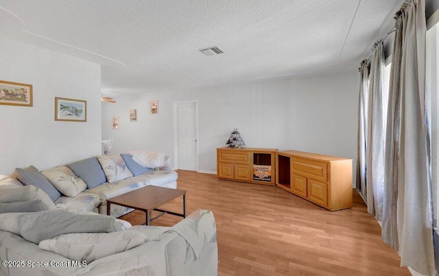 631 Dundee Cir, Melbourne, FL 32904 - living room featuring a textured ceiling and light wood finished floors