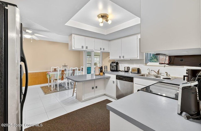 631 Dundee Cir, Melbourne, FL 32904 - kitchen with stainless steel appliances, a peninsula, light tile patterned floors, wainscoting, and white cabinetry