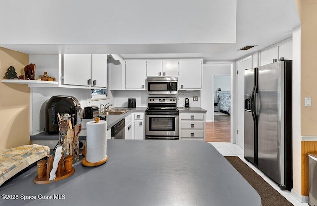 631 Dundee Cir, Melbourne, FL 32904 - kitchen featuring stainless steel appliances, white cabinets, open shelves, and a peninsula