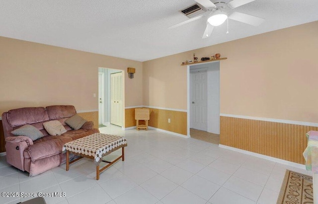 631 Dundee Cir, Melbourne, FL 32904 - living area with a wainscoted wall, wooden walls, a textured ceiling, and ceiling fan