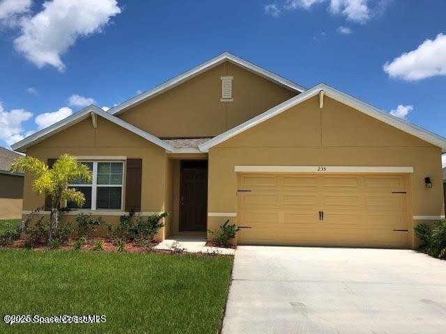235 Sorrento Dr, Cocoa, FL 32922 - ranch-style home with stucco siding, concrete driveway, a garage, and a front lawn