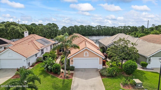 442 Carmel Dr, Melbourne, FL 32940 - view of front facade with driveway, an attached garage, a front yard, and a tile roof