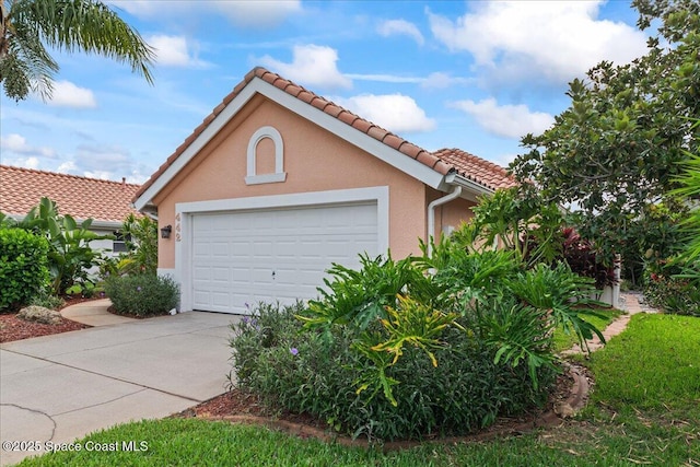 442 Carmel Dr, Melbourne, FL 32940 - view of front of property with concrete driveway, a tiled roof, stucco siding, and an attached garage