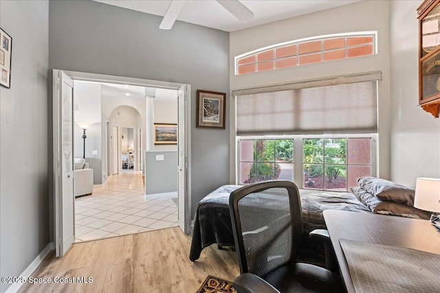 442 Carmel Dr, Melbourne, FL 32940 - bedroom with arched walkways, a high ceiling, light wood-style flooring, and ceiling fan