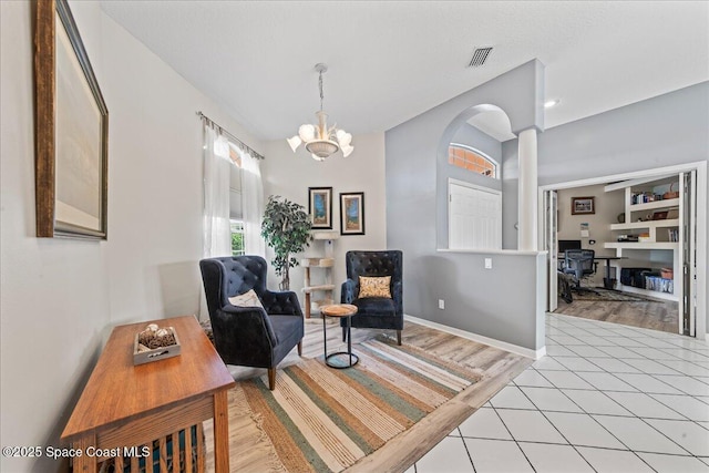 442 Carmel Dr, Melbourne, FL 32940 - living area featuring a desk, light tile patterned floors, and a chandelier