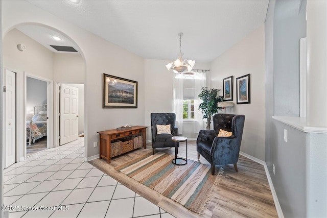 442 Carmel Dr, Melbourne, FL 32940 - sitting room featuring arched walkways, a chandelier, and light wood-style floors