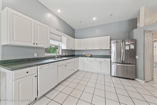 442 Carmel Dr, Melbourne, FL 32940 - kitchen featuring freestanding refrigerator, white dishwasher, dark countertops, white cabinetry, and recessed lighting