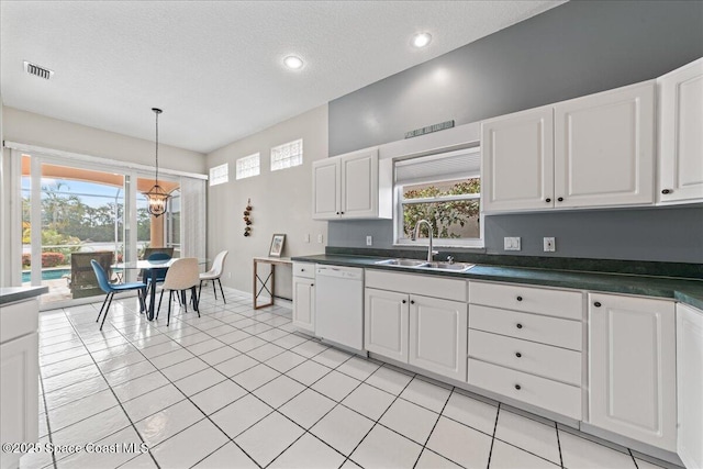 442 Carmel Dr, Melbourne, FL 32940 - kitchen featuring white dishwasher, dark countertops, white cabinets, pendant lighting, and a chandelier