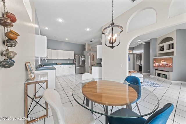442 Carmel Dr, Melbourne, FL 32940 - dining space featuring ceiling fan, arched walkways, a chandelier, light tile patterned floors, and built in shelves