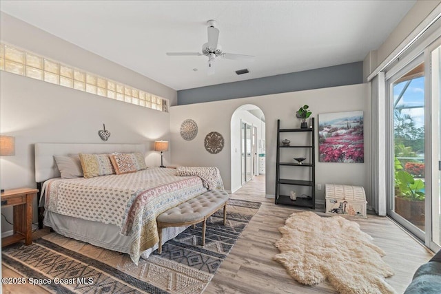 442 Carmel Dr, Melbourne, FL 32940 - bedroom featuring access to outside, multiple windows, arched walkways, and light wood-style flooring