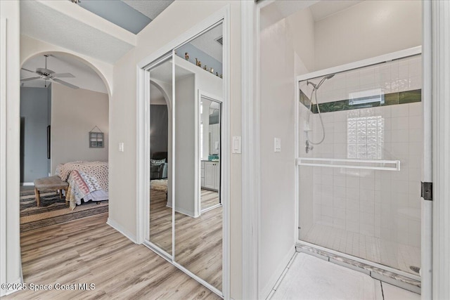 442 Carmel Dr, Melbourne, FL 32940 - bathroom with a shower stall, ceiling fan, connected bathroom, and wood finished floors